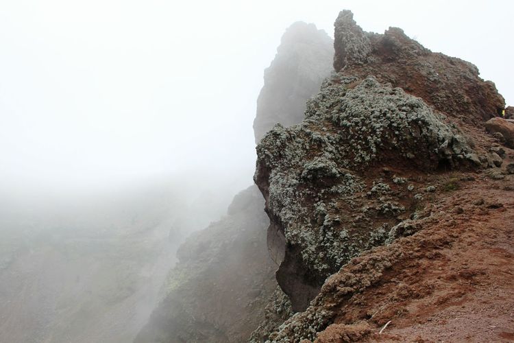 Rock formations on mountain in foggy weather