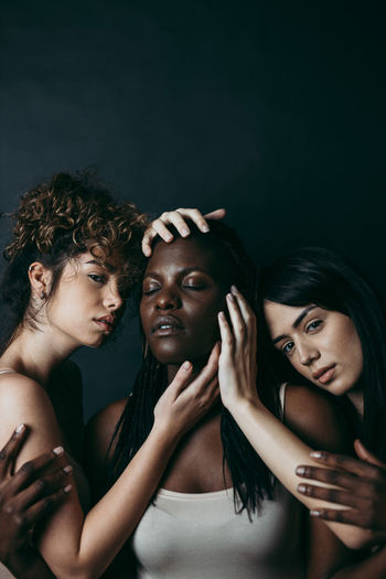 Portrait of young couple against black background