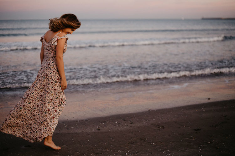 Full length of woman at beach during sunset