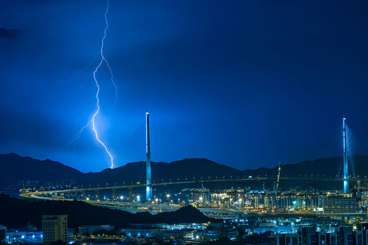 Lightning over illuminated buildings in city at night