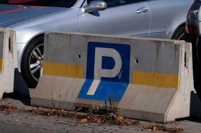 Blue and white car parking sign on a concrete block