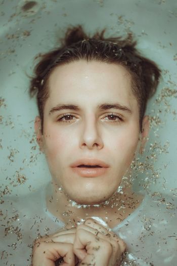 Close-up portrait of scared man in bathtub