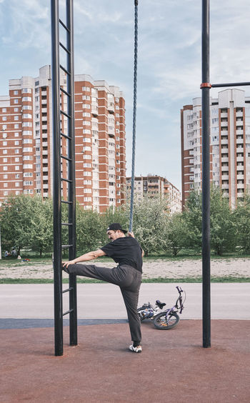 Senior asian man is training on the sports ground in the park against the background of cityscape