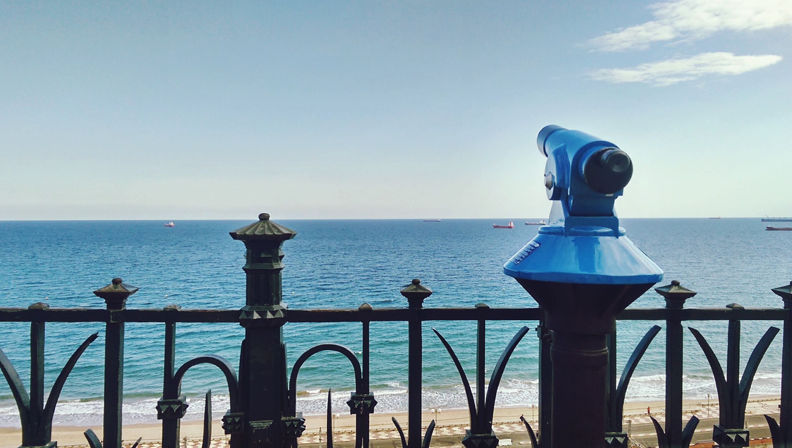 sea, railing, water, horizon over water, sky, coin-operated binoculars, scenics, hand-held telescope, tranquil scene, blue, tranquility, outdoors, metal, day, nature, no people, telescope, cloud - sky, beauty in nature, travel destinations, close-up