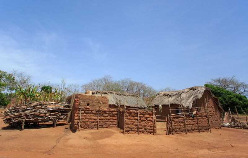 Wooden hut on landscape against blue sky