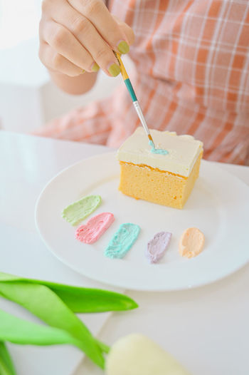 Close-up of hand holding ice cream in plate