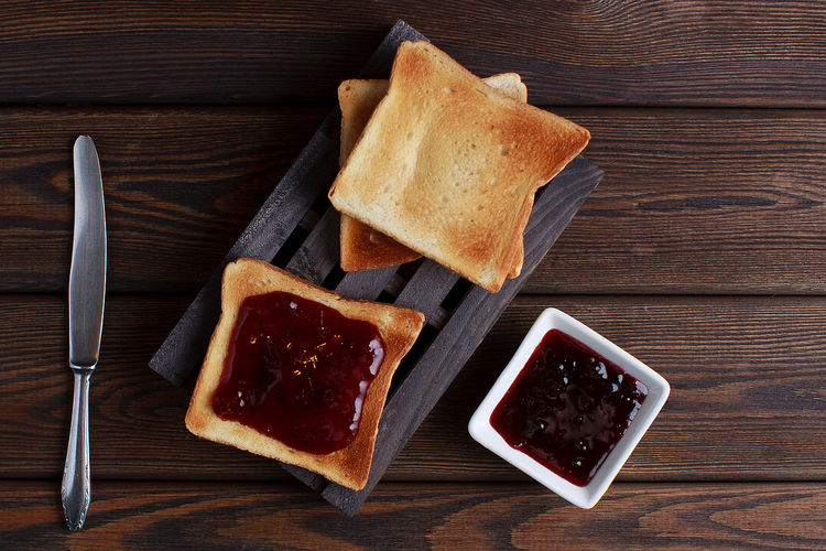 Toasts with jam on dark wooden table