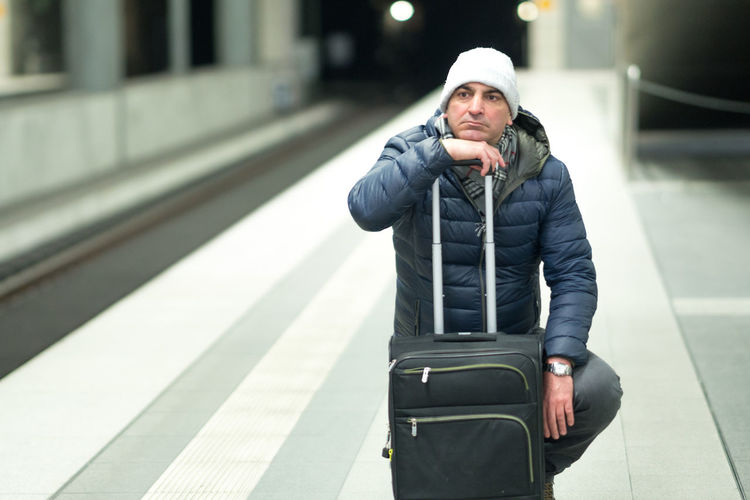 Man with luggage at railroad station platform