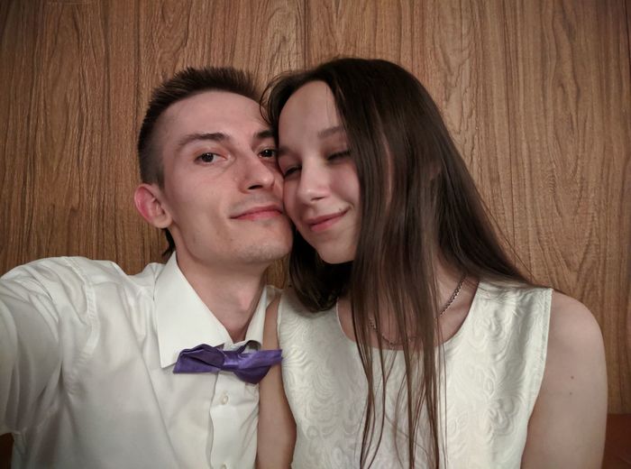 Portrait of man with girlfriend against wooden wall