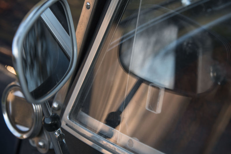 Close up of side mirror and side window of classic car with reflection