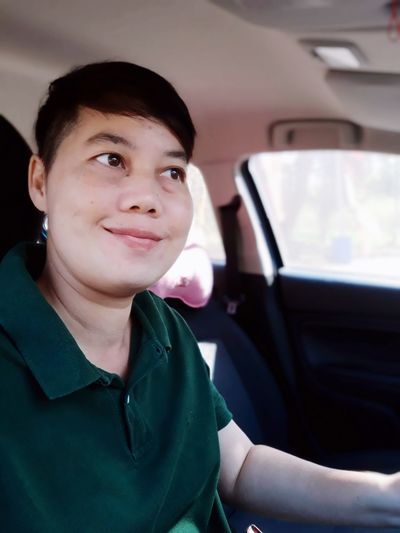 Smiling woman looking away in car