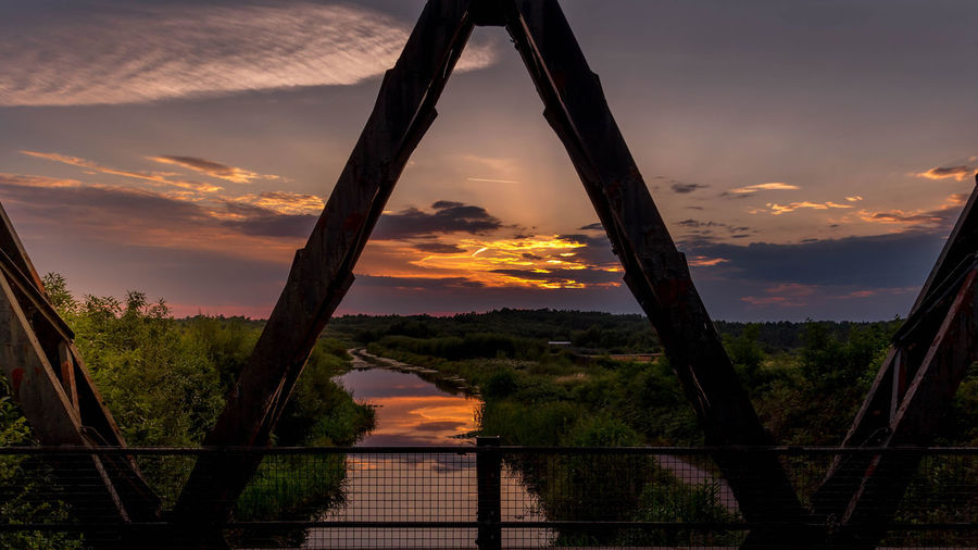 Silhouette bridge against sky during sunset
