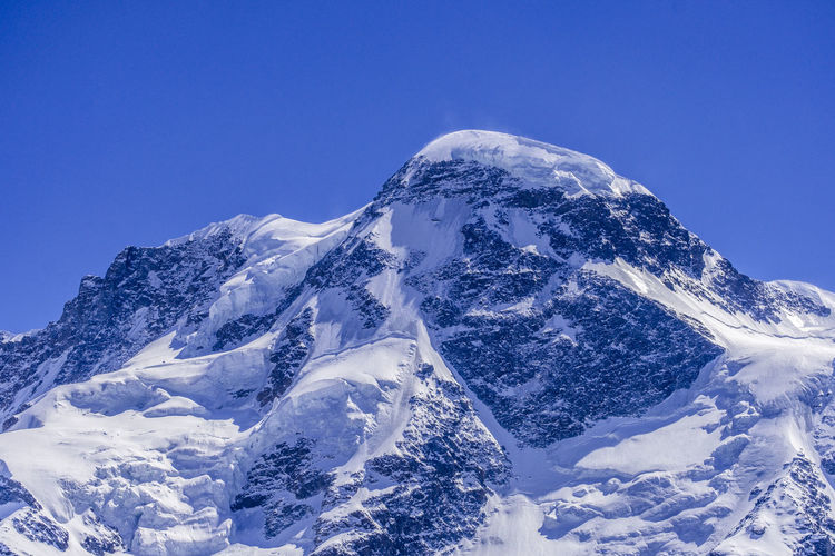 Scenic view of snowcapped mountain against clear blue sky