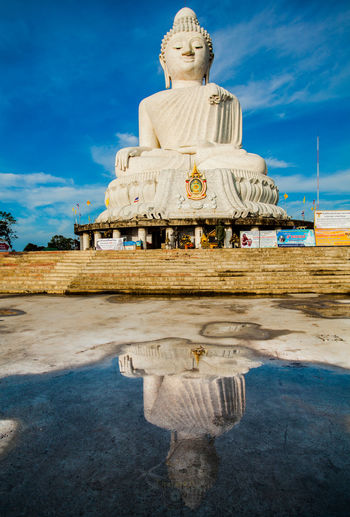 Giant buddha statue against blue sky