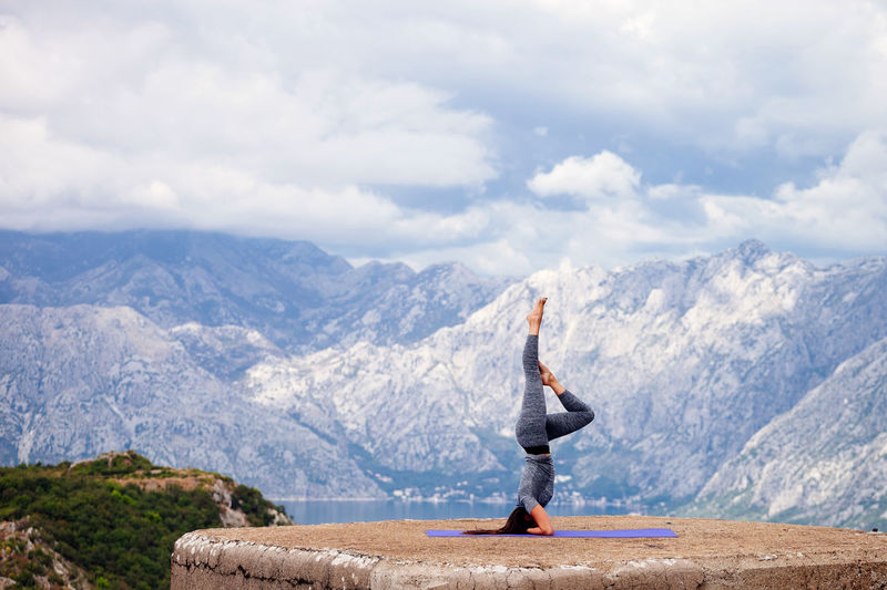 Woman practicing yoga against snowcapped mountains