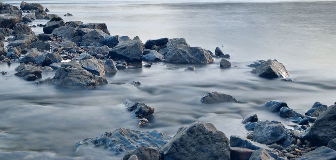 Panoramic view of rocks on beach against sky