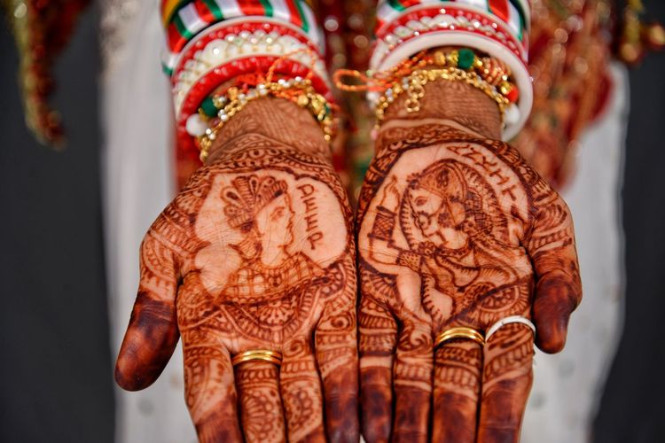 Cropped hands of bride with heena tattoo