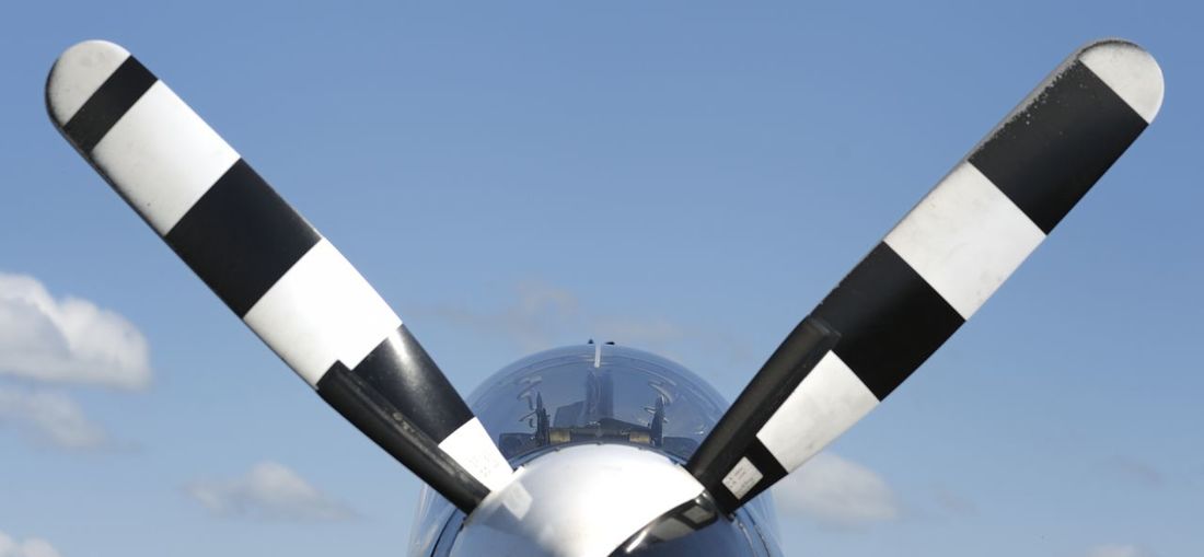 Low angle view of airplane propeller against clear blue sky