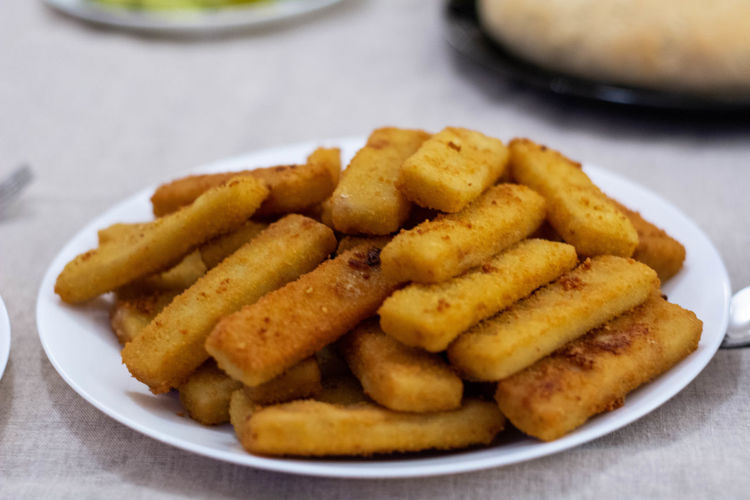 Close-up of fish fingers in the plate on the table