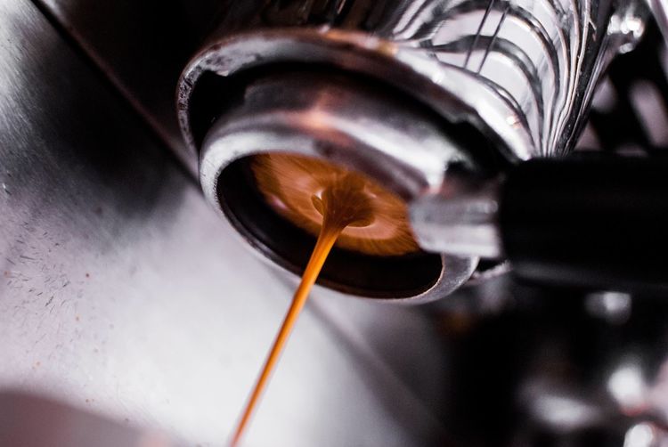 Close-up of coffee dripping from machinery