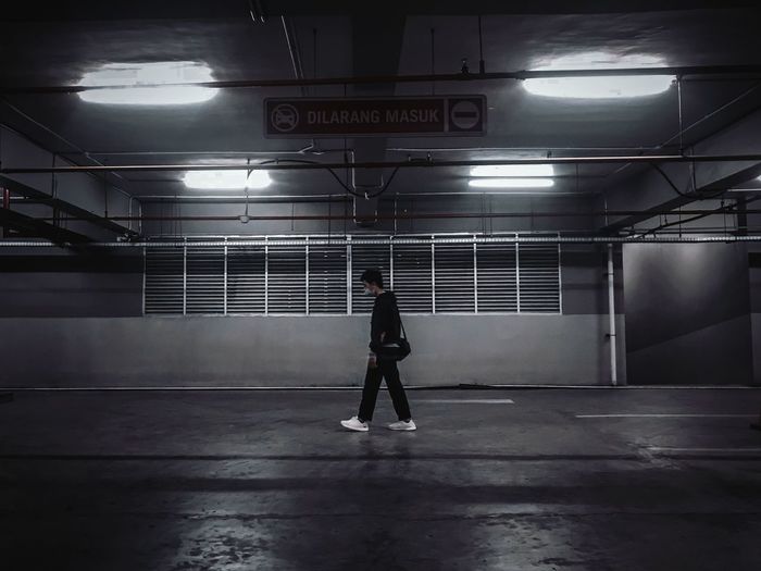 Rear view of man standing on illuminated subway