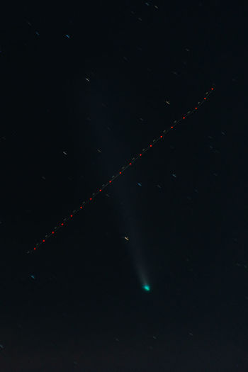 Low angle view of illuminated lights against sky at night with the comet neowise