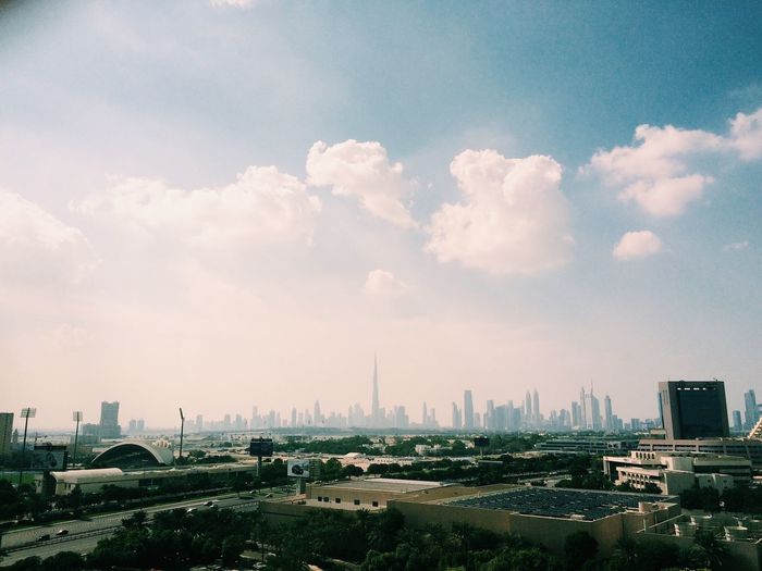 Buildings against cloudy sky on sunny day in city