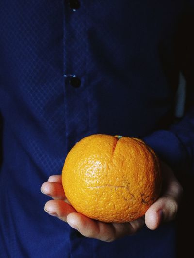 Close-up of hand holding orange