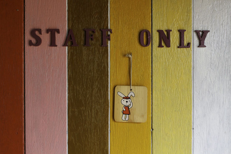 Close-up of restroom sign on wooden door