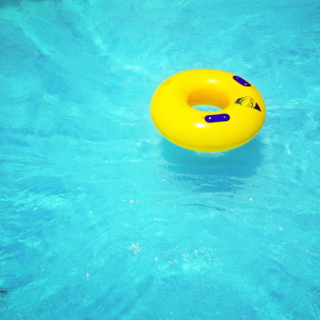 blue, yellow, water, swimming pool, circle, close-up, high angle view, waterfront, ball, multi colored, turquoise colored, single object, childhood, no people, toy, orange color, geometric shape, sport, wall - building feature, rippled