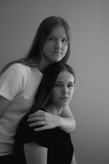 Portrait of female friends against gray background
