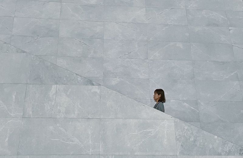High angle view of woman standing against white wall