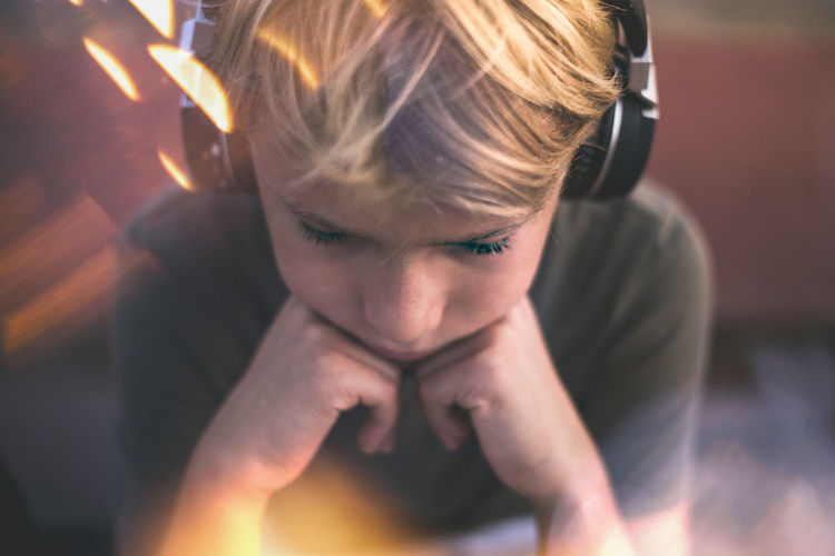 Trendy teen enjoying the sound with headphones. boy with earphones relax alone listening music. 