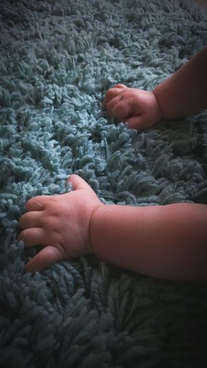 Cropped image of toddler playing on rug at home