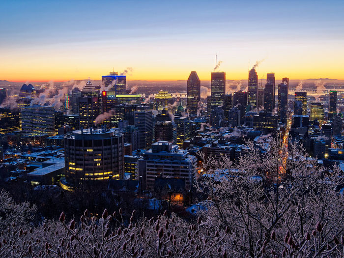 Illuminated buildings in city at sunset
