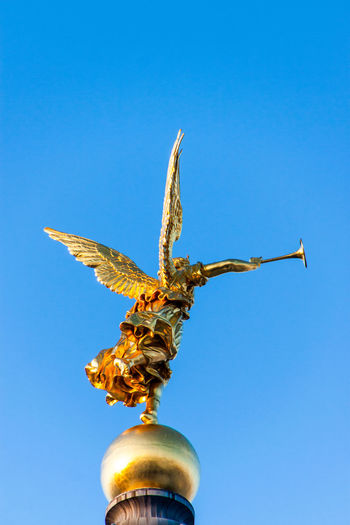 Low angle view of angel statue on dresden frauenkirche against clear sky
