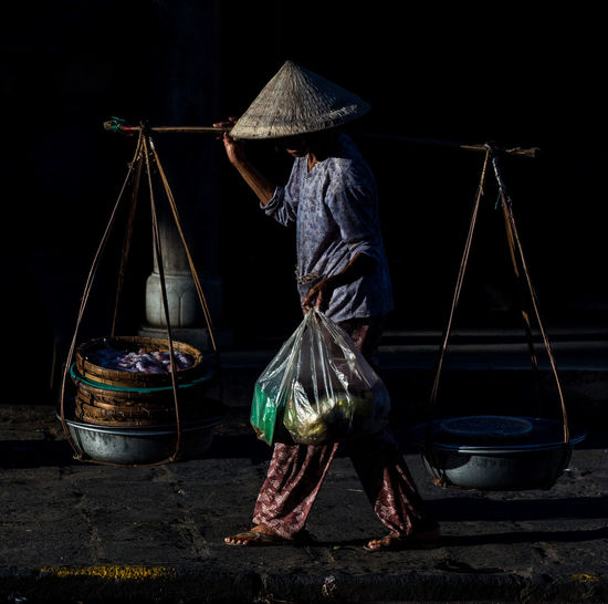 Vietnamese vendor walking at market