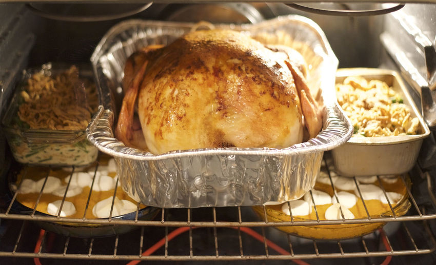  thanksgiving feast and turkey roasting in the oven 
