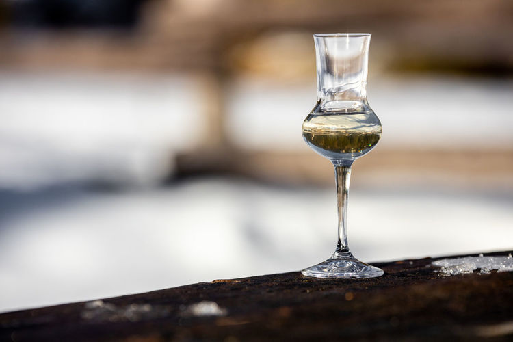 Bokeh picture of a flavored grappa schnapps glass in cortina d'ampezzo, dolomites, italy