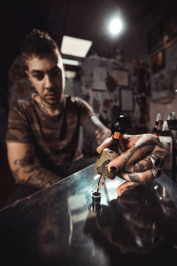 Young man holding ink at workshop
