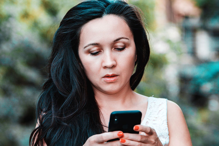 Close-up of woman using mobile phone outdoors