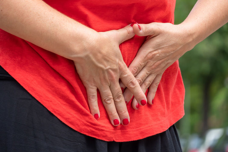 Midsection of woman touching stomach