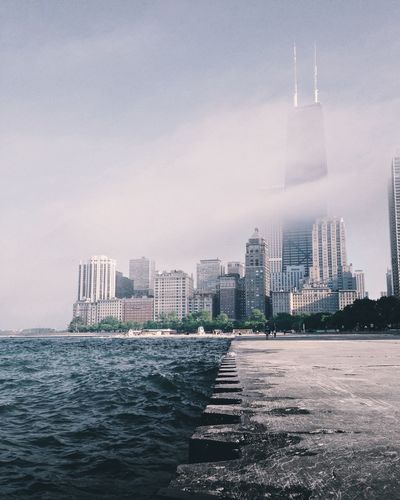 Willis tower by lake michigan against sky in city