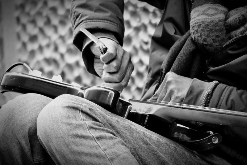 Midsection of man playing guitar