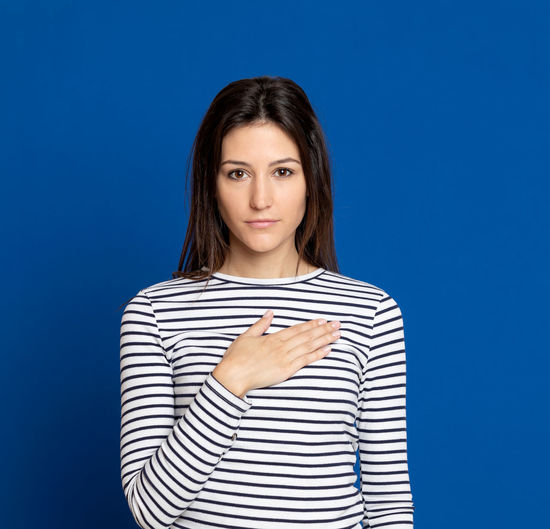 Portrait of beautiful young woman against blue background