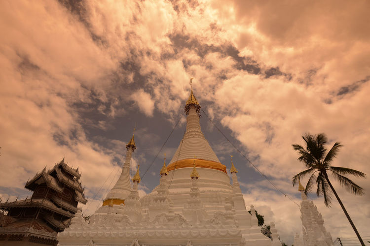 Low angle view of pagoda against cloudy sky during sunset