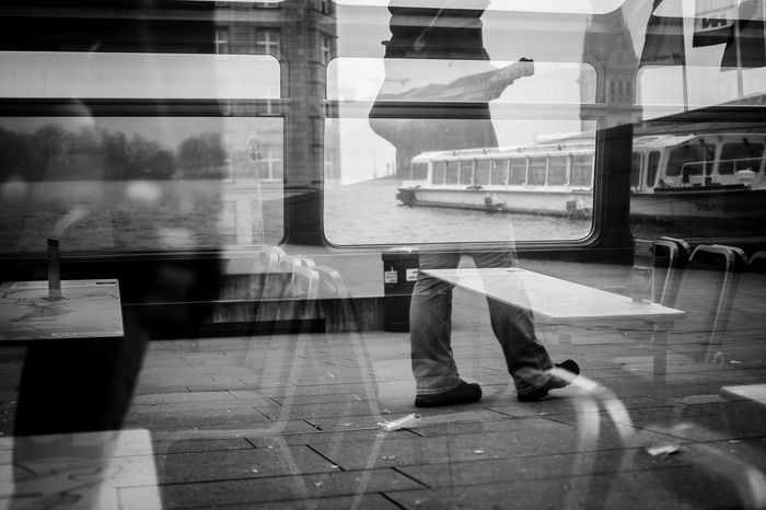 Reflection of man walking on bus window