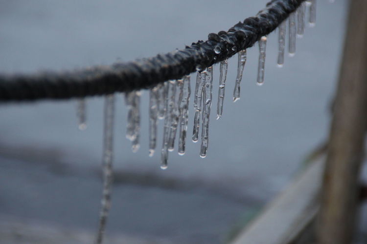 Close-up of icicles hanging from metal during winter