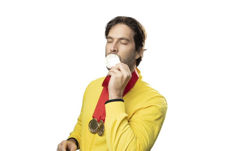 Portrait of young man holding ice cream against white background