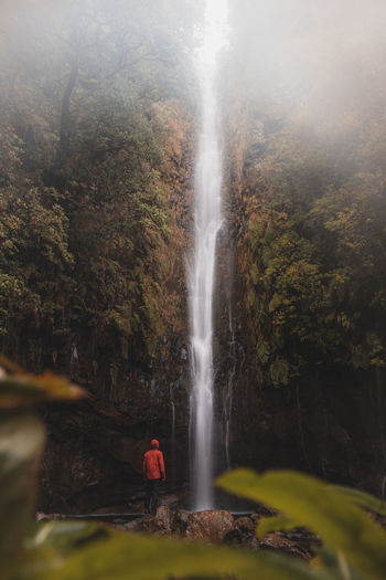 25 fontes waterfall rises in the mist and rain on the island of madeira, portugal.
